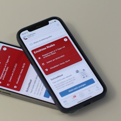 Die Kacheln in der Corona-Warn-App leuchten auf zwei Handys rot.