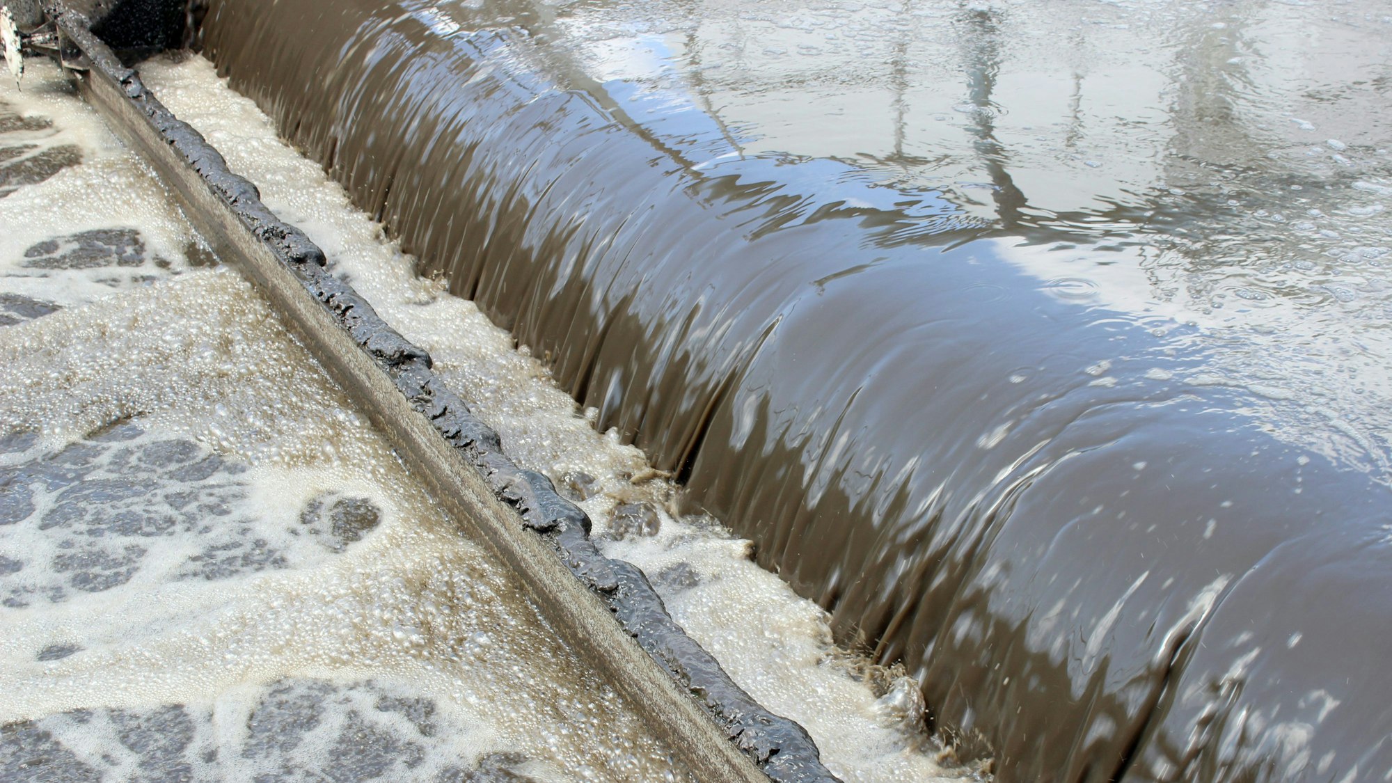 Wasser läuft durch ein Belebungsbecken in einem Klärwerk.