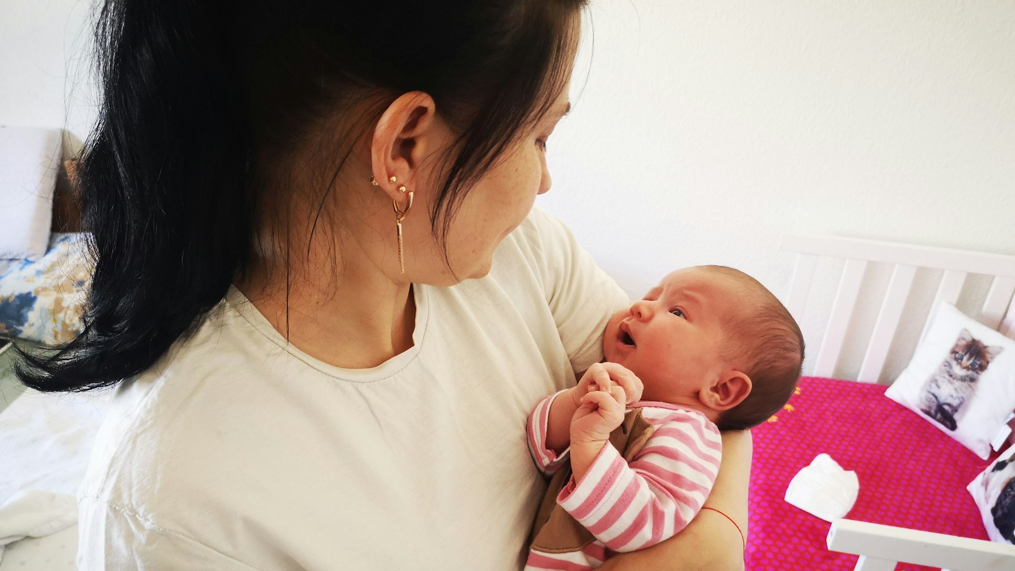 Eine Frau hält ein Neugeborenes auf dem Arm.