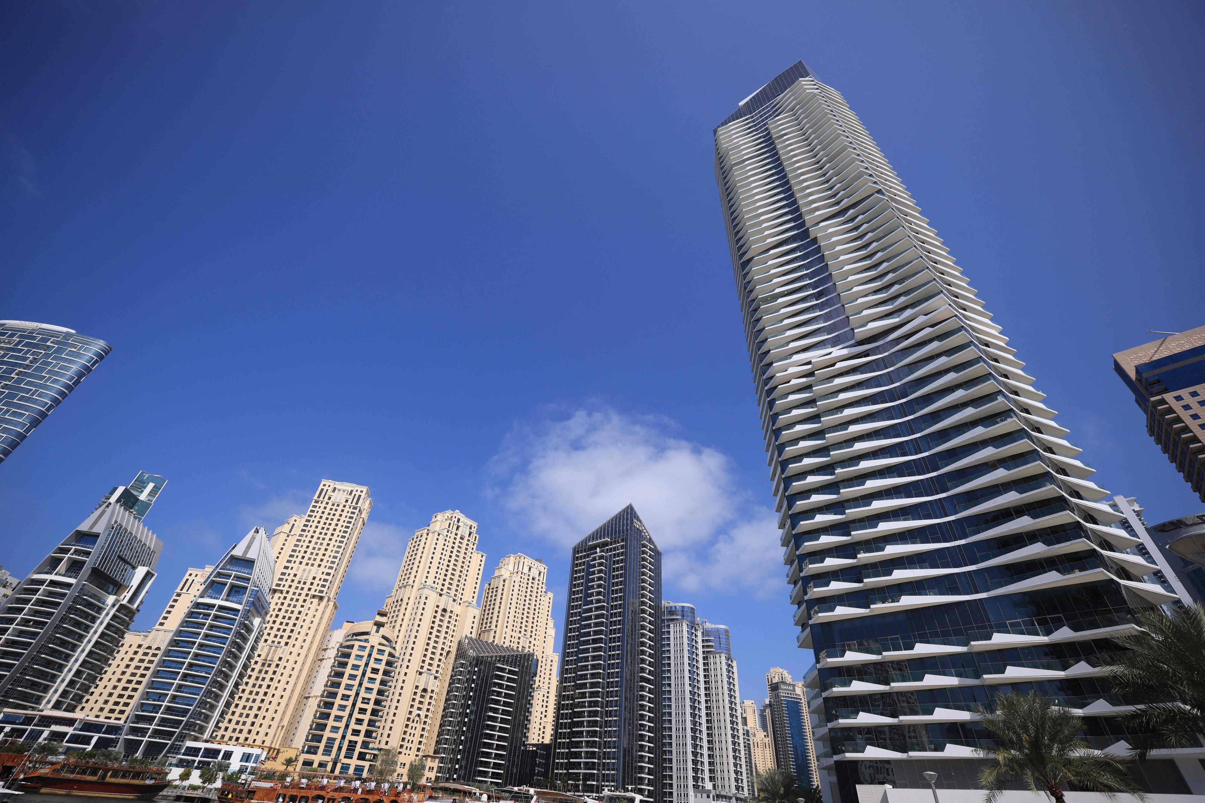 Die Hochhäuser in Dubai ragen vor einem strahlend blauen Himmel in die Höhe.