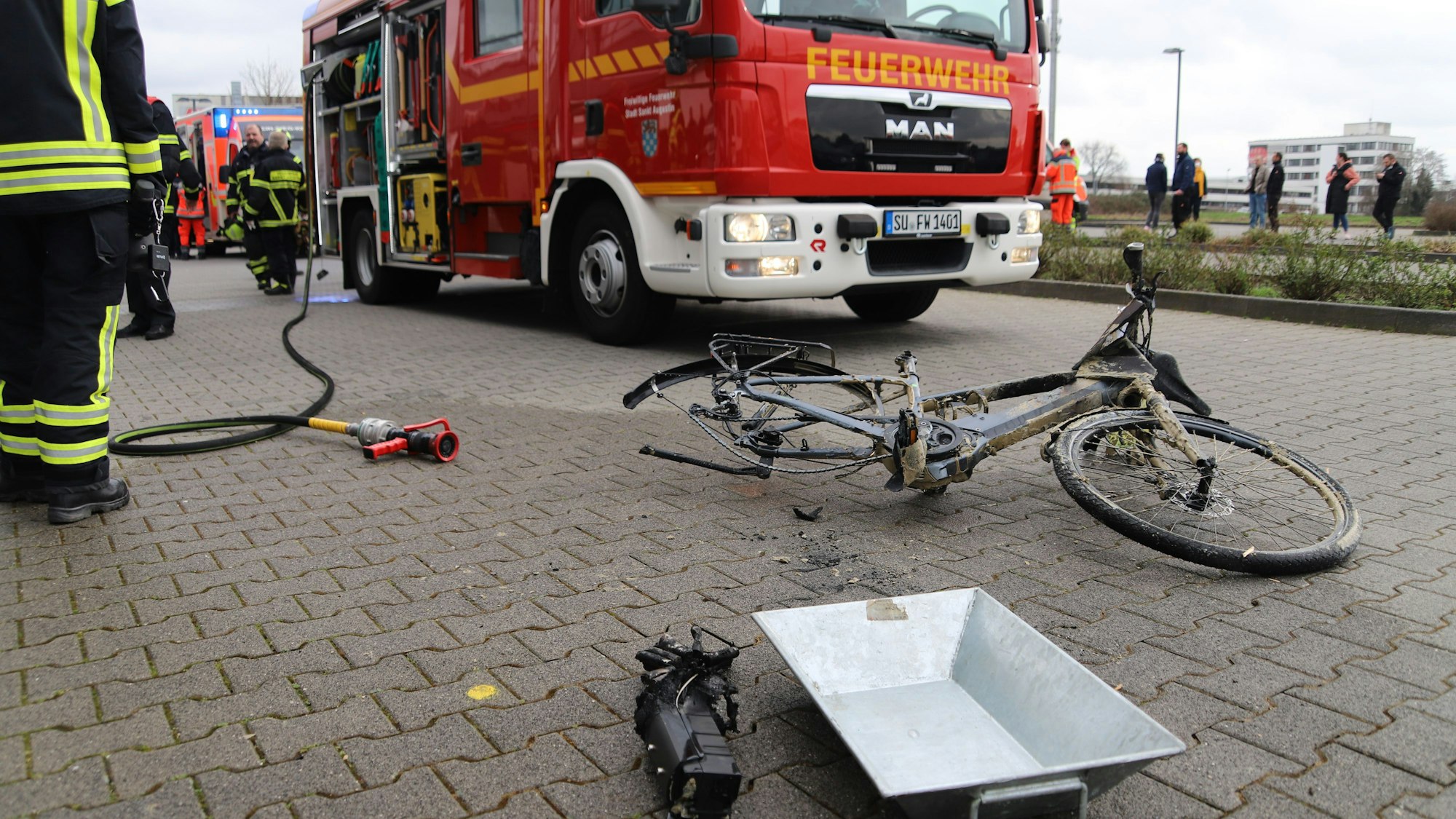 Ein kaputtes Pedelec liegt vor einem Einsatzwagen der Feuerwehr.