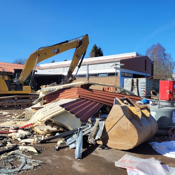 Ein Abrissbagger steht vor der früheren Grundschule in Kall.