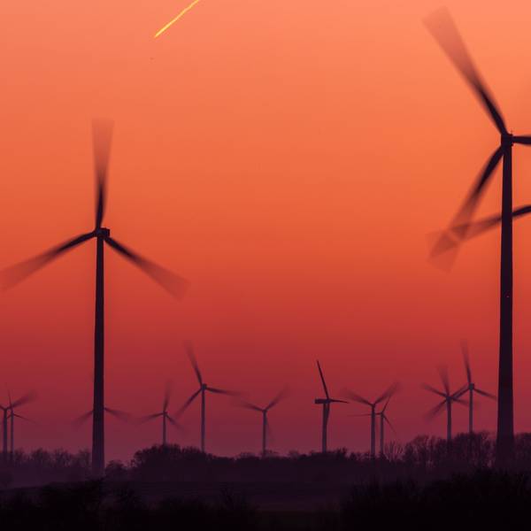 Die Rotoren von Windkraftanlagen drehen sich nach Sonnenuntergang.