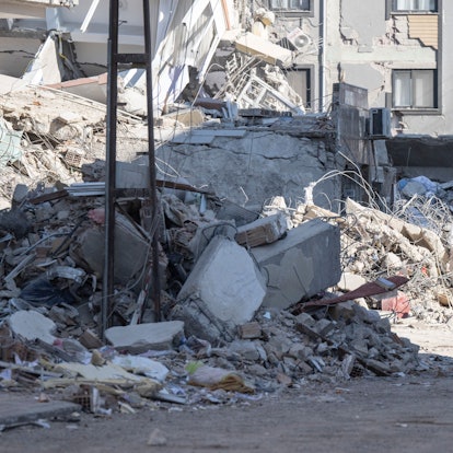 Zwei Männer gehen durch Trümmer in der Innenstadt von Kirikhan.