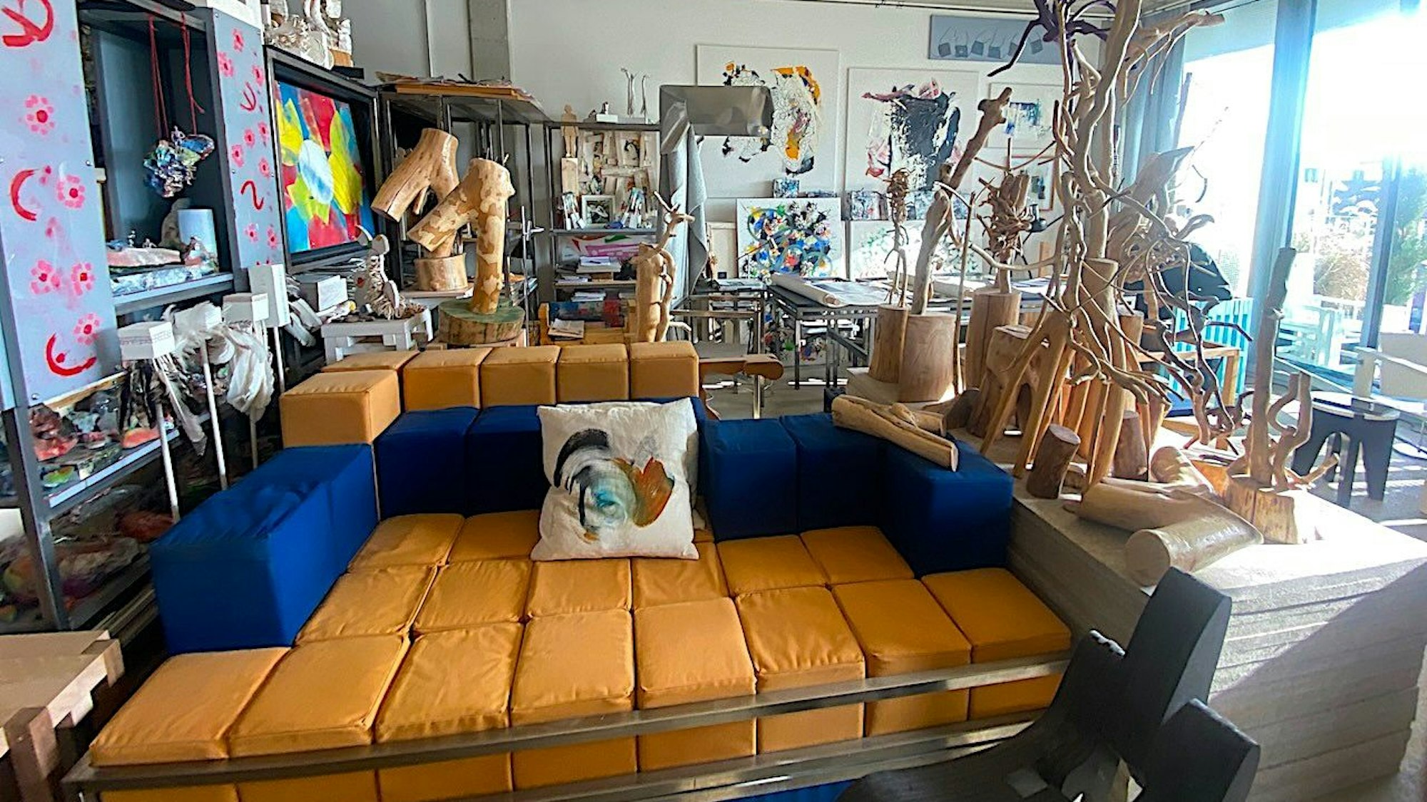 Das Loft der beiden mit Couch und Holzfiguren.