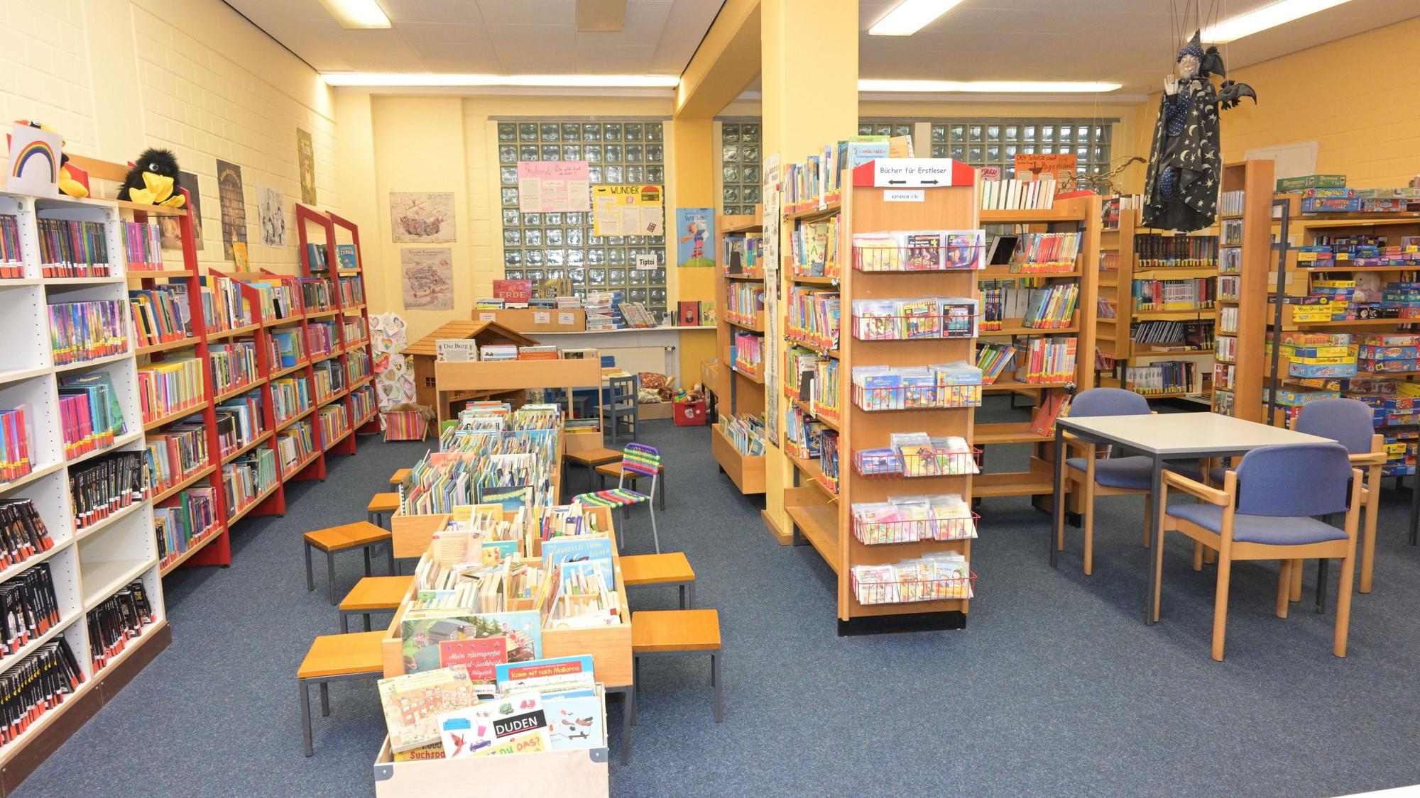 In der Katholischen öffentlichen Bücherei in Kürten stehen Regale und Tische, die voll mit Büchern sind.