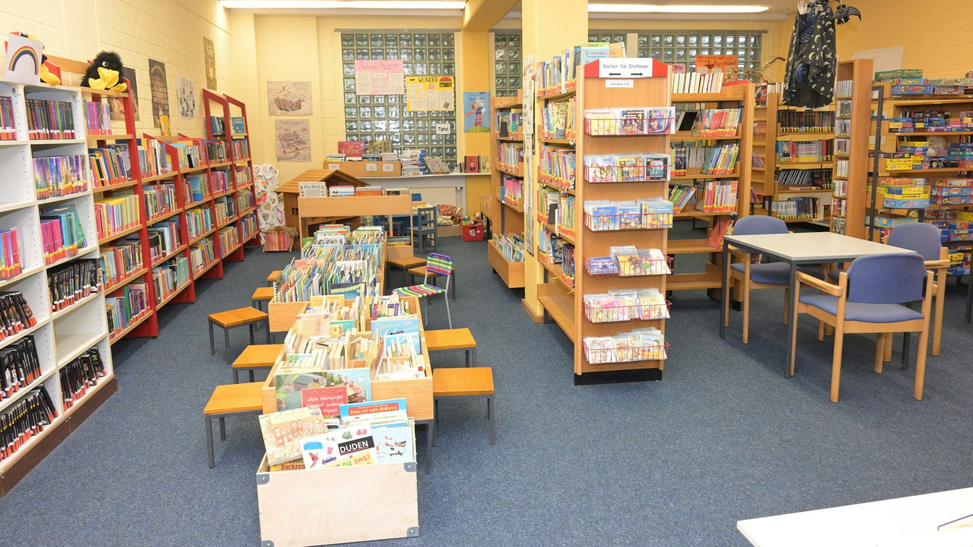 Zu sehen sind Bücherregale sowie Lesetische für Kinder und Erwachsene.