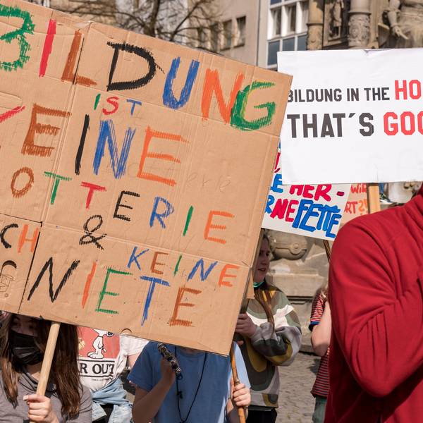Ein Kind hält auf einer Demo ein selbst bemaltes Schild hoch.