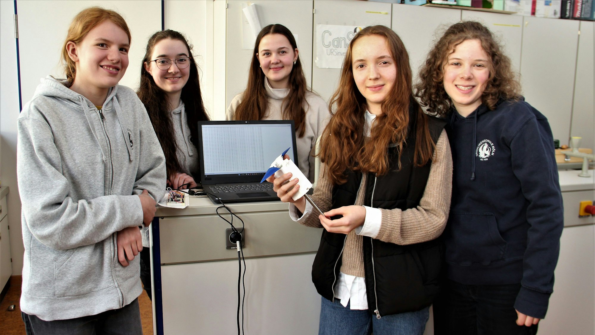 Fünf Schülerinnen stehen neben dem Satelliten