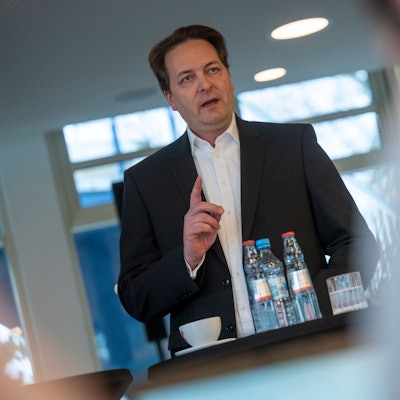 Das Bild zeigt CDU-Politiker Karl Alexander Mandl im Anzug an einem Stehtisch.