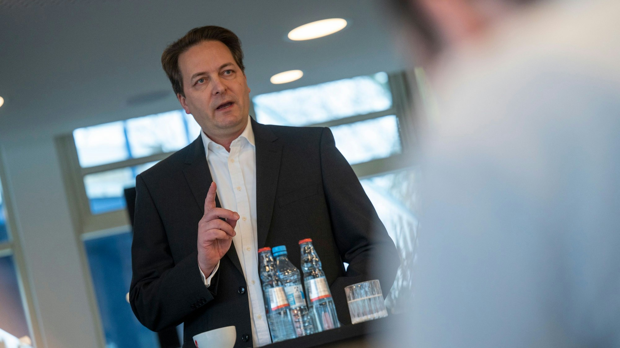 Das Bild zeigt CDU-Politiker Karl Alexander Mandl im Anzug an einem Stehtisch.