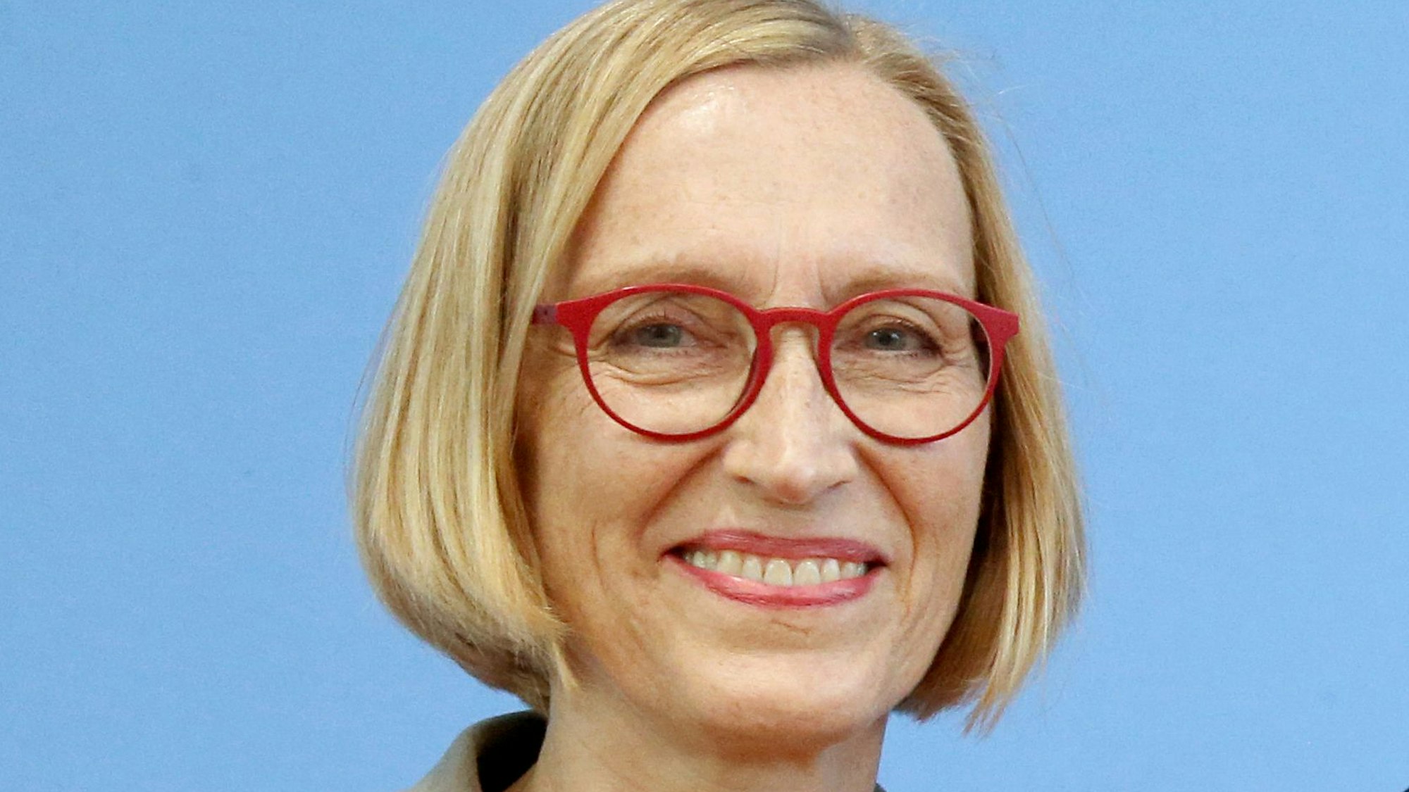 Sabine Walper trägt einen kinnlangen, blonden Bob und eine rote Brille.