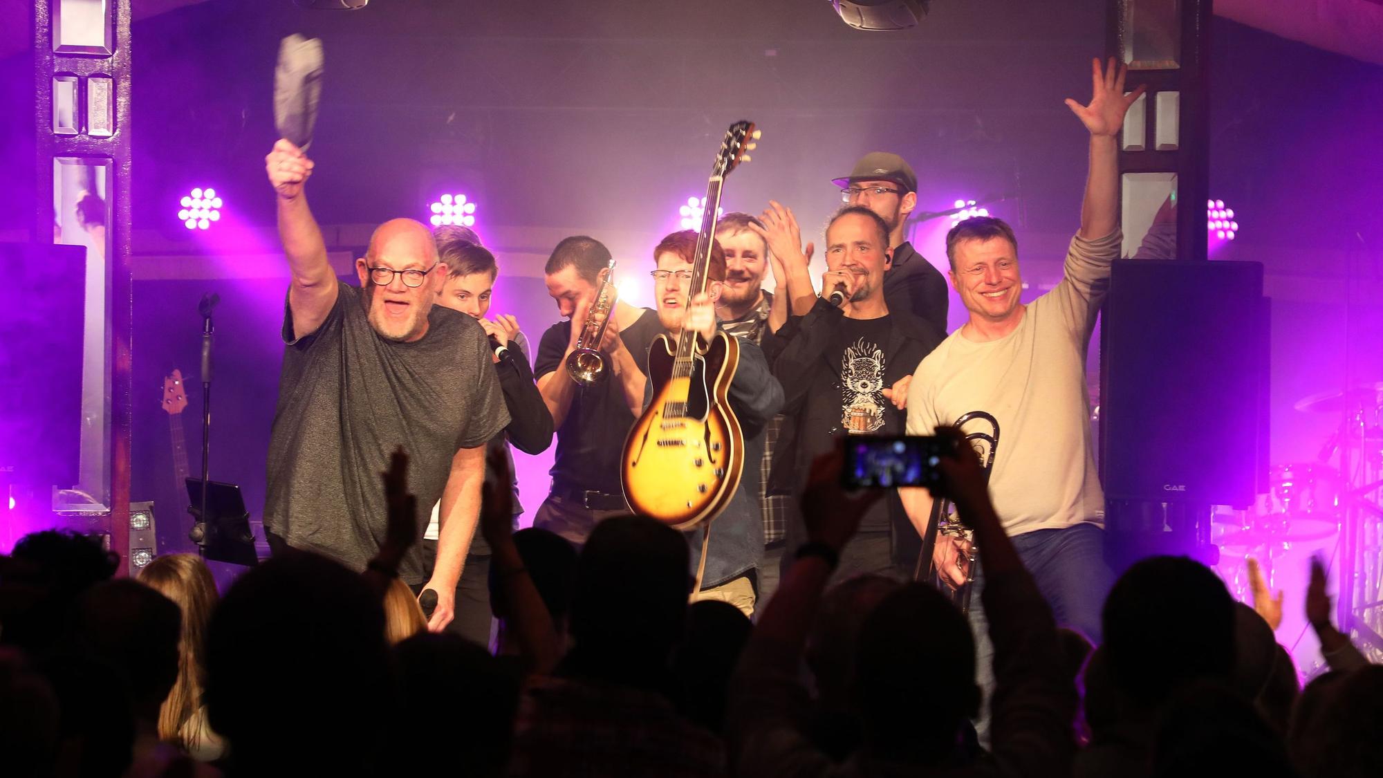 Die ehemalige Wise Guys Clemens Tewinkel und Eddi Hüneke stehen mit den Musikern der Band von Jakob Tewinkel auf der Bühne des Altenberger Spiegelzelts.