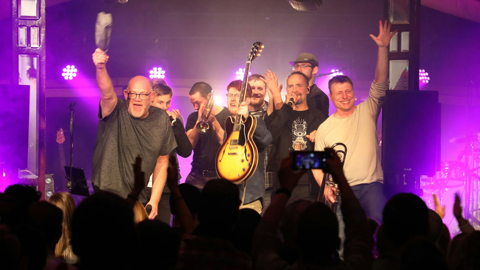 Die ehemalige Wise Guys Clemens Tewinkel und Eddi Hüneke stehen mit den Musikern der Band von Jakob Tewinkel auf der Bühne des Altenberger Spiegelzelts.