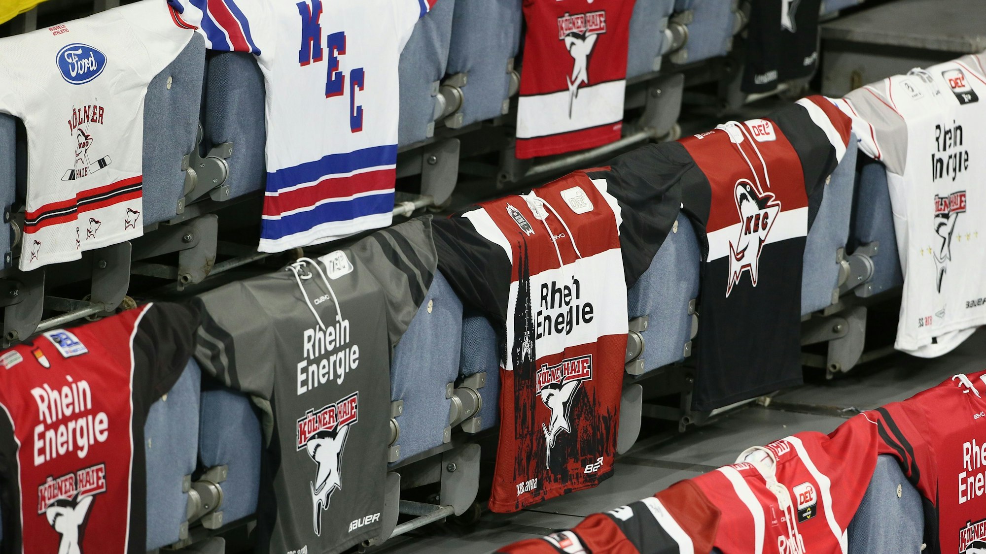 Mehrere KEC-Trikots liegen auf der Tribüne der Kölner Haie aus.