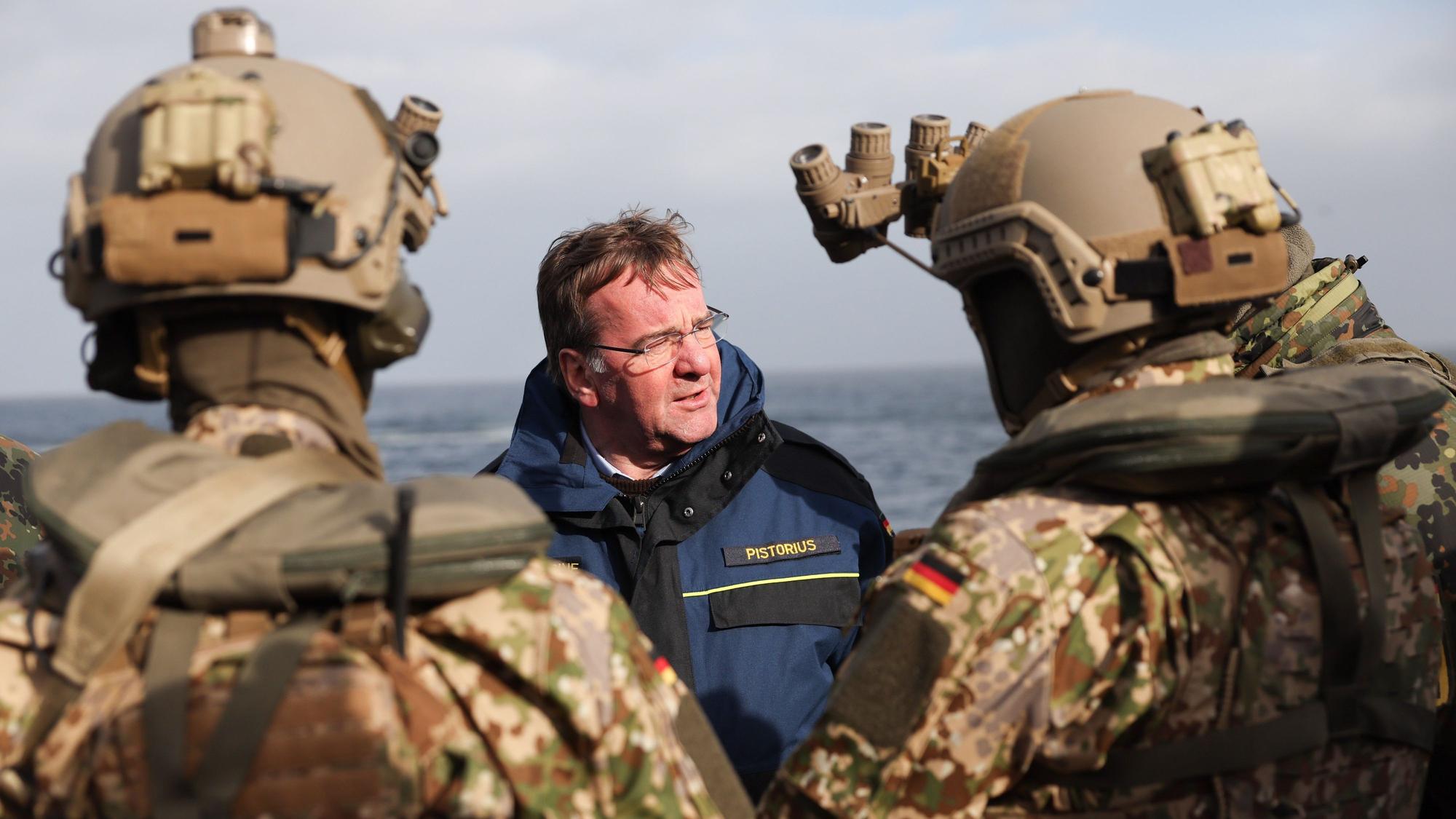 Boris Pistorius (SPD, M), Bundesminister der Verteidigung, spricht mit Soldaten des KSM (Kommando Spezialkräfte Marine) bei einer Demonstration an Bord der Fregatte Hessen. Pistorius ist für einen Antrittsbesuch bei der Marine auf dem Marinestützpunkt Eckernförde.