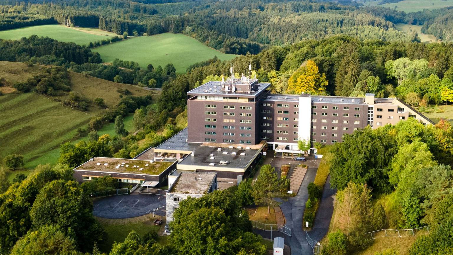 Das große Gebäude der früheren Eifelhöhen-Klinik in Marmagen, die jetzt als Unterkunft für Geflüchtete genutzt wird, liegt am Ortsrand von Marmagen und ist von idyllischer Natur umgeben.