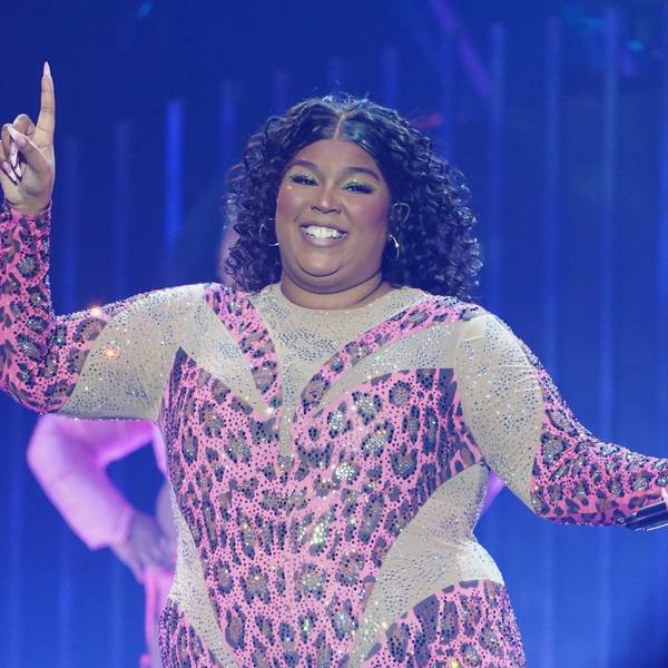 Die US-amerikanische Sängerin Lizzo steht in einem funkelden Anzug im Leoparden-Look auf der Bühne.
