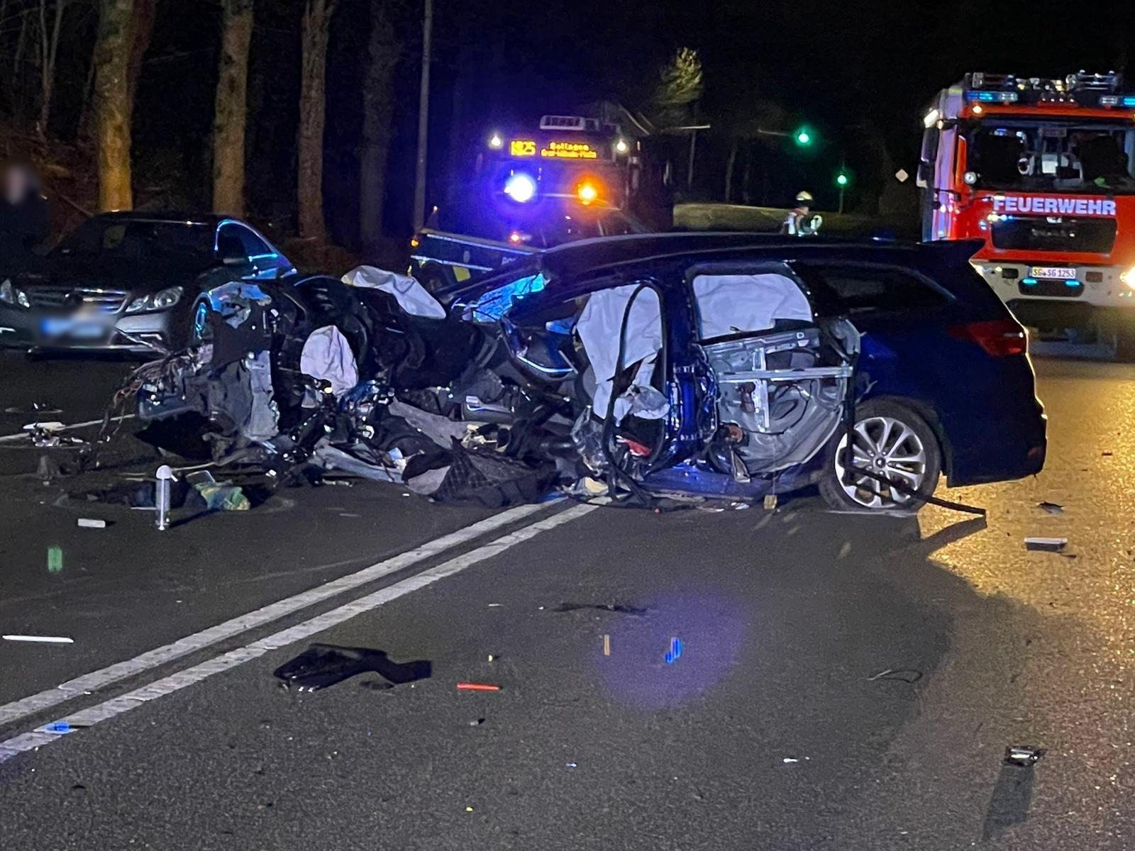 Ein zerstörtes Auto steht auf der Bundesstraße 229 vor einem Fahrzeug der Feuerwehr.