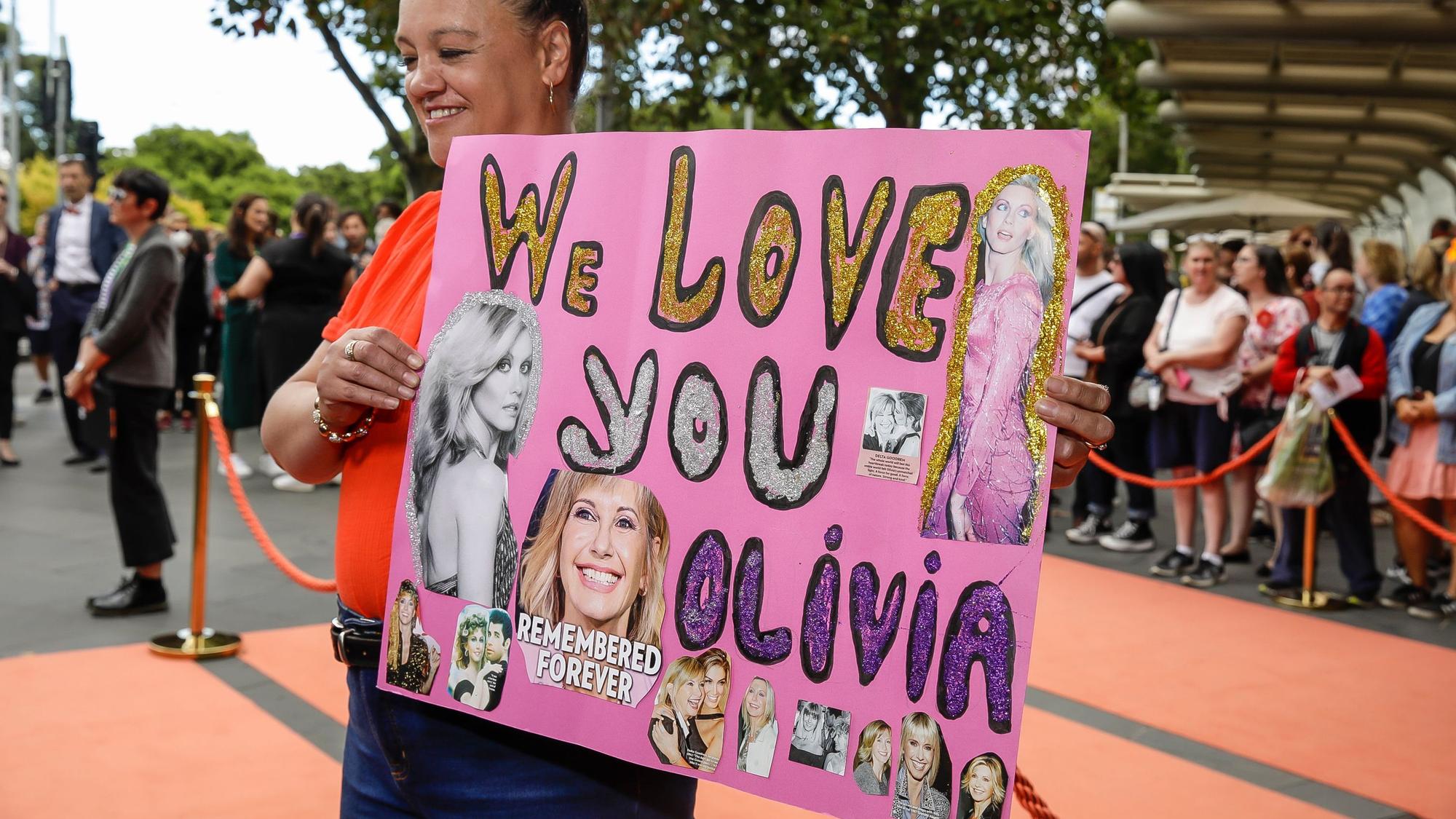 Justine Edwards mit einem Olivia-Plakat.
