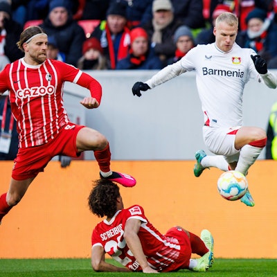 dpatopbilder - 26.02.2023, Baden-Württemberg, Freiburg im Breisgau: Fußball: Bundesliga, SC Freiburg - Bayer Leverkusen, 22. Spieltag, Europa-Park Stadion. Leverkusens Mitchel Bakker (r) in Aktion gegen Freiburgs Lucas Höler (l) und Freiburgs Kiliann Sildillia (M). Foto: Tom Weller/dpa - WICHTIGER HINWEIS: Gemäß den Vorgaben der DFL Deutsche Fußball Liga bzw. des DFB Deutscher Fußball-Bund ist es untersagt, in dem Stadion und/oder vom Spiel angefertigte Fotoaufnahmen in Form von Sequenzbildern und/oder videoähnlichen Fotostrecken zu verwerten bzw. verwerten zu lassen. +++ dpa-Bildfunk +++