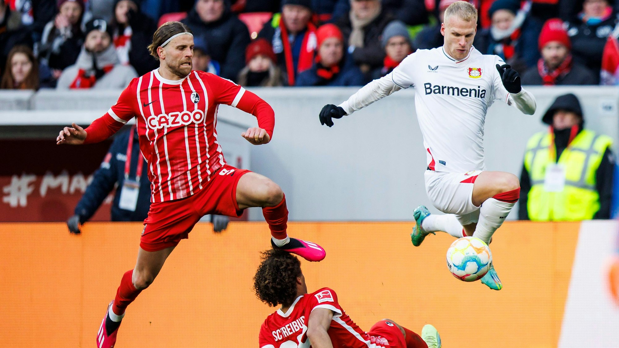 dpatopbilder - 26.02.2023, Baden-Württemberg, Freiburg im Breisgau: Fußball: Bundesliga, SC Freiburg - Bayer Leverkusen, 22. Spieltag, Europa-Park Stadion. Leverkusens Mitchel Bakker (r) in Aktion gegen Freiburgs Lucas Höler (l) und Freiburgs Kiliann Sildillia (M). Foto: Tom Weller/dpa - WICHTIGER HINWEIS: Gemäß den Vorgaben der DFL Deutsche Fußball Liga bzw. des DFB Deutscher Fußball-Bund ist es untersagt, in dem Stadion und/oder vom Spiel angefertigte Fotoaufnahmen in Form von Sequenzbildern und/oder videoähnlichen Fotostrecken zu verwerten bzw. verwerten zu lassen. +++ dpa-Bildfunk +++