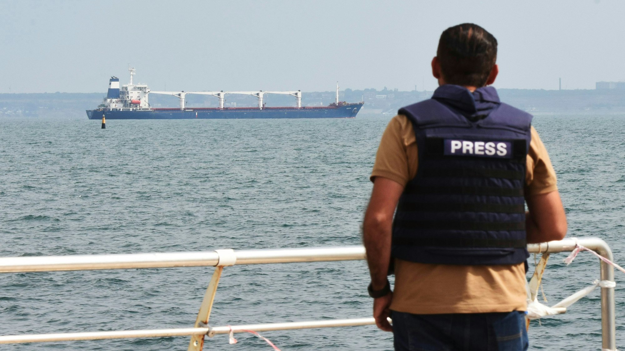 Ein Journalist beobachtet, wie das unter der Flagge von Sierra Leone fahrende Frachtschiff Razoni mit 26.000 Tonnen ukrainischem Getreide an Bord den Hafen von Odessa verlässt.
