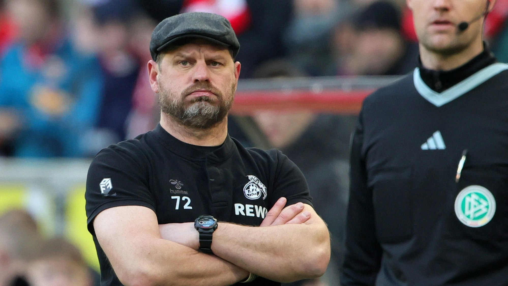 FC-Trainer Steffen Baumgart steht mit verschränkten Armen am Spielfeldrand; der 1. FC Köln verlor am Samstag gegen den VfL Wolfsburg 0:2.