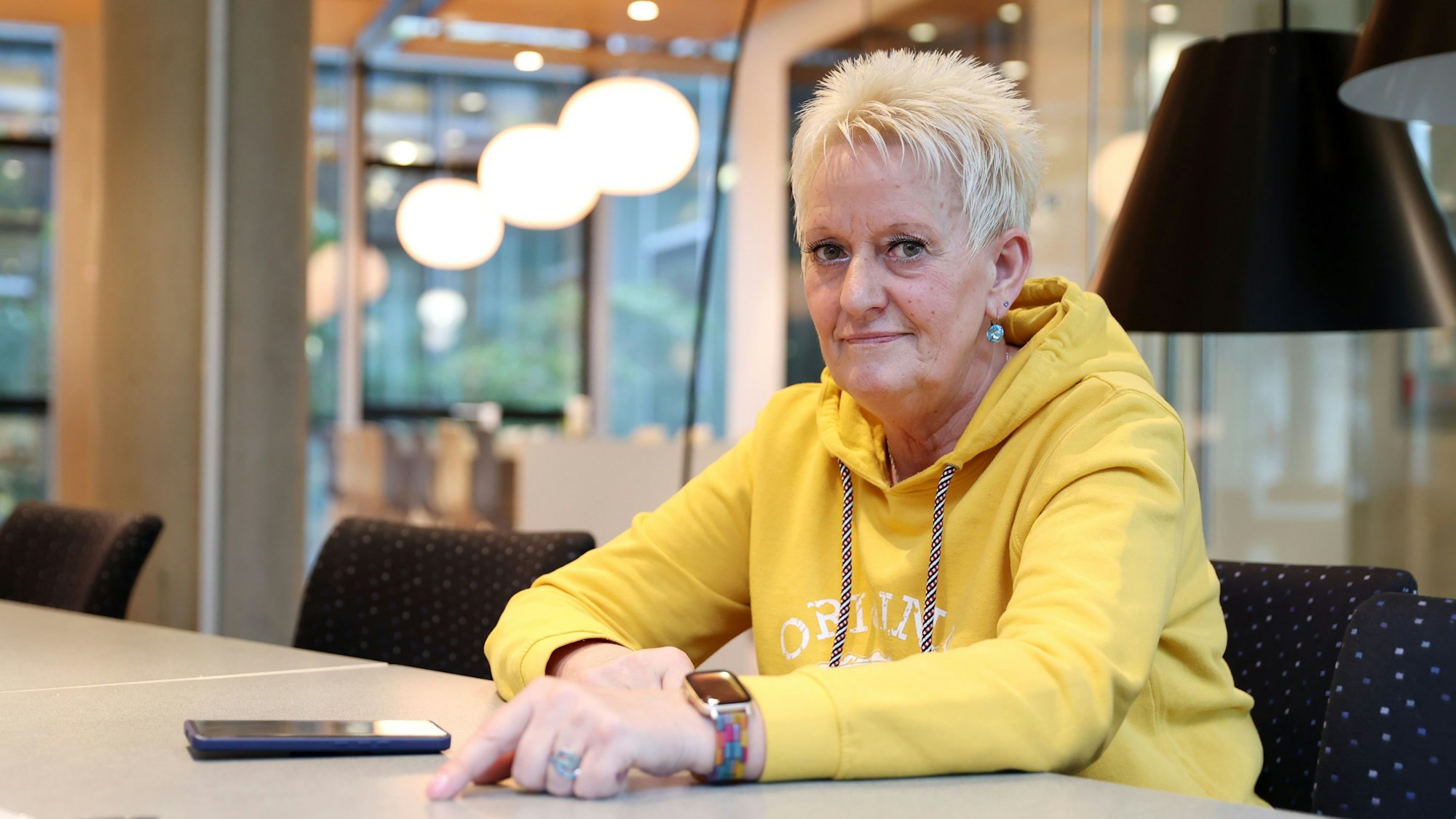 Anka Milow sitzt an einem Tisch und schaut in die Kamera