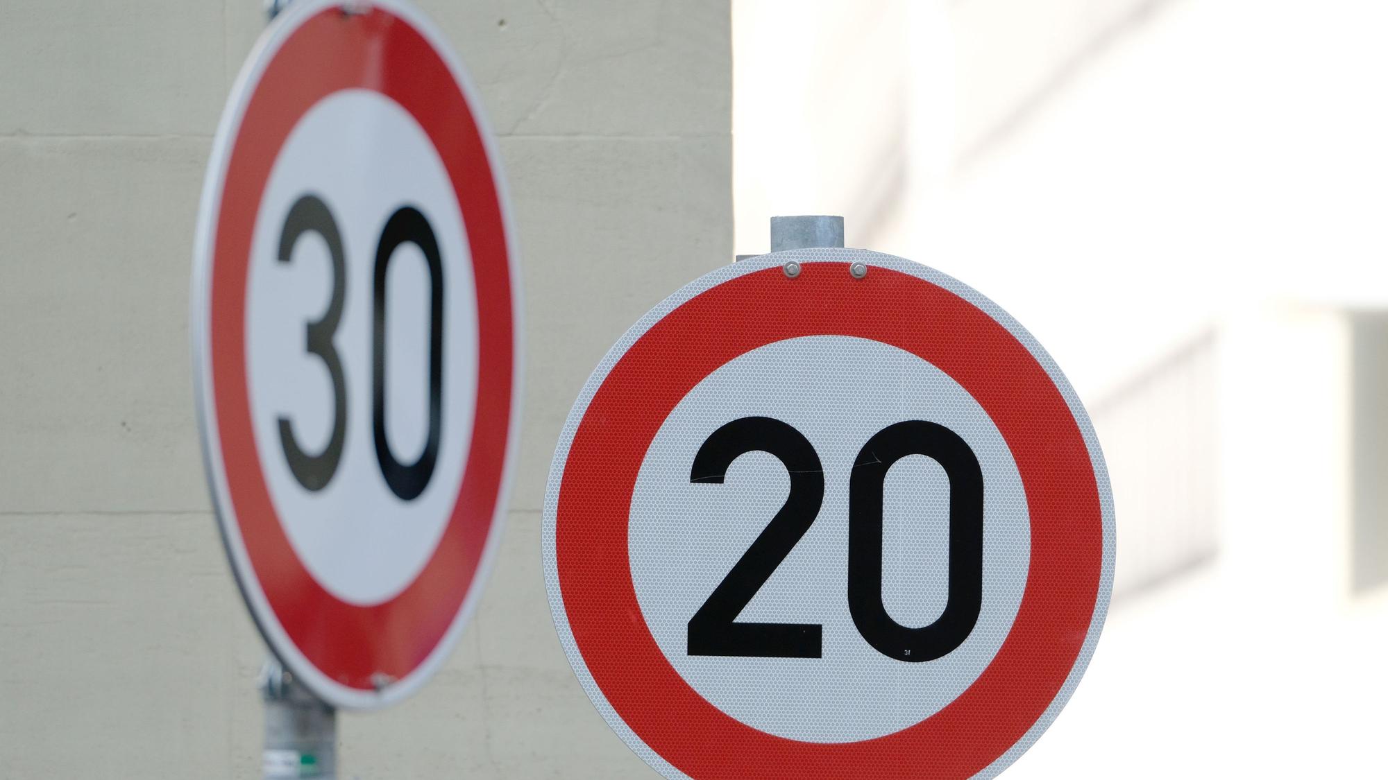 Straßenschilder mit dem Hinweis Tempo 20 und Tempo 30 sind in der Innenstadt in Stuttgart an einer Kreuzung von zwei Straßen angebracht