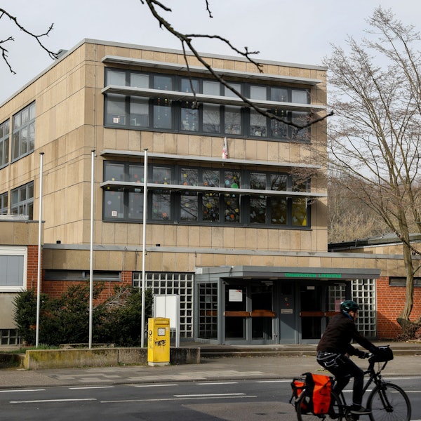 Ein Schulgebäude steht an einer Straße.