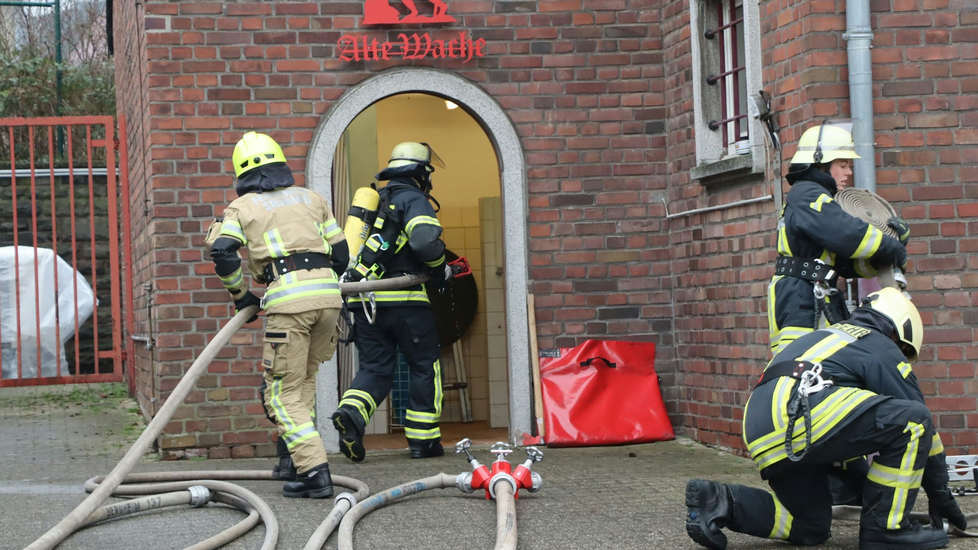 Das Foto zeigt die angehenden Feuerwehrleute beim Betreten eines verrauchten Gebäudes.
