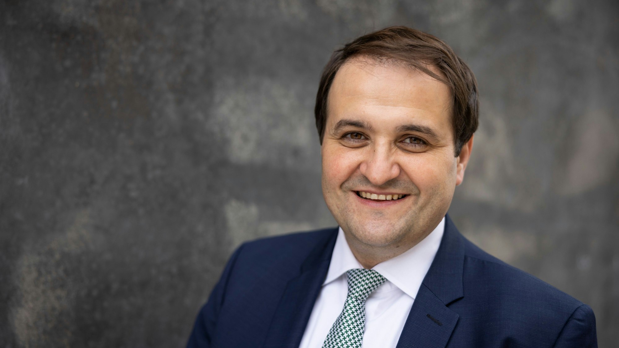 Nathanael Liminski (CDU) trägt ein blaues Jackett und eine blau-weiß karierte Krawatte.