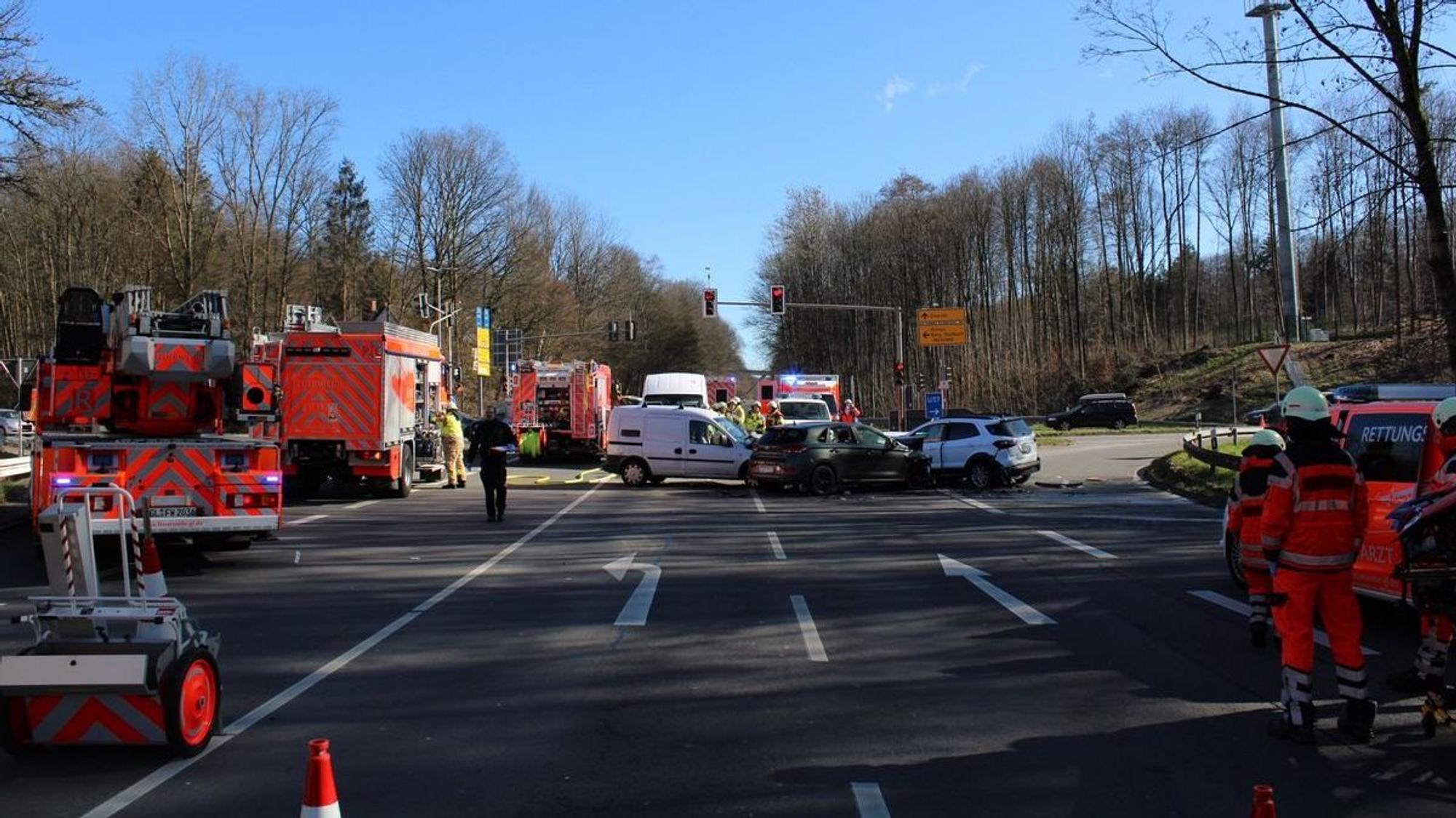 An der Unfallstelle stehen mehrere Feuerwehrleute und Einsatzwagen.