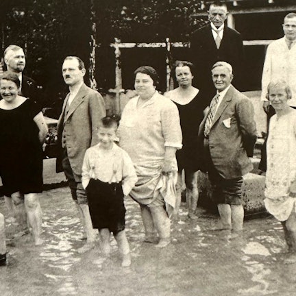 Mehrere Menschen stehen knöcheltief in einem Becken.