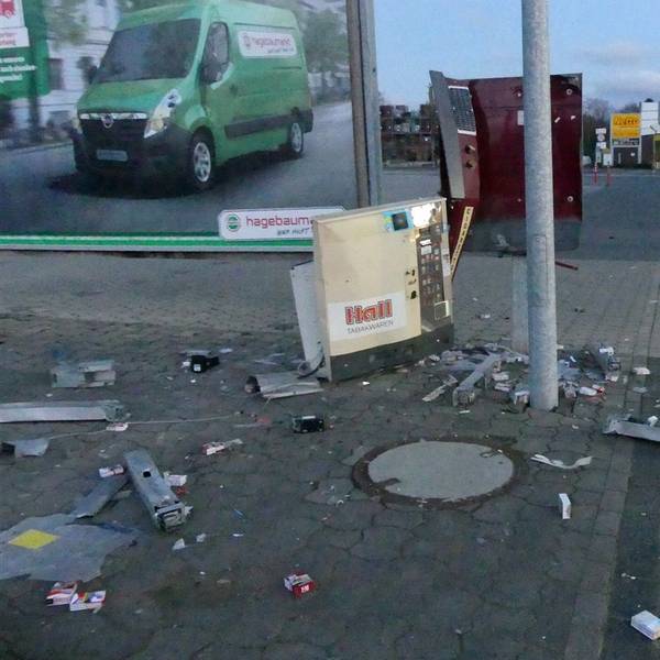 Teile eines in die Luft gesprengten Zigarettenautomaten liegen auf einer Straße verteilt.