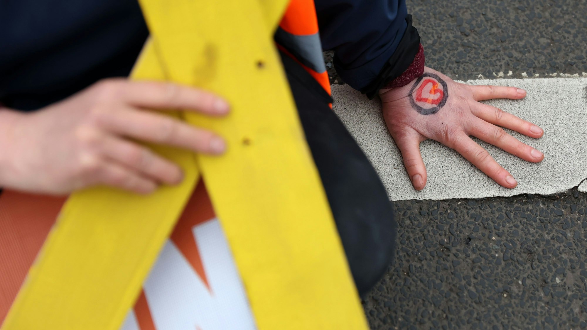 Eine auf dem Asphalt festgeklebte Hand.