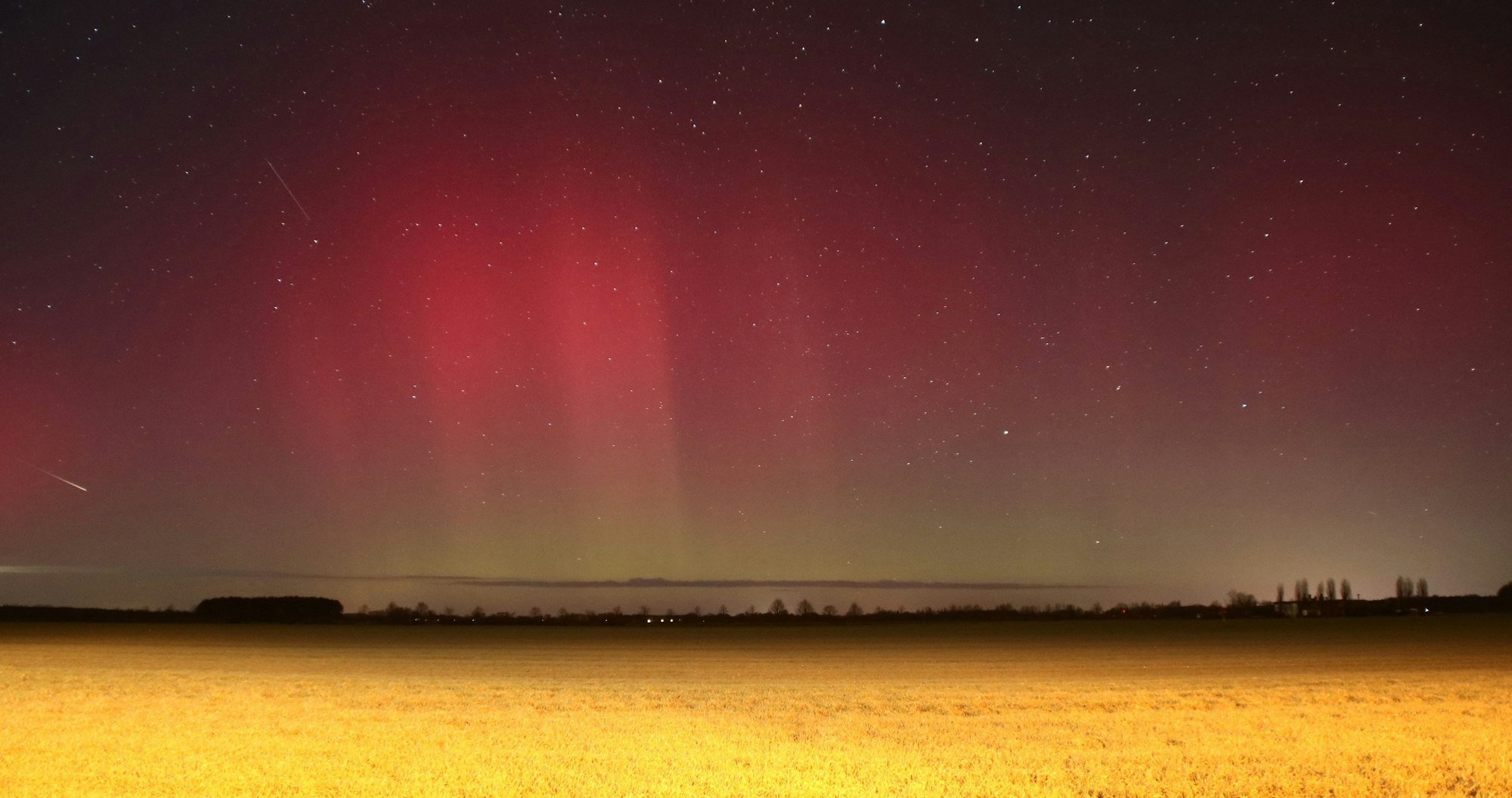 Polarlichter leuchten über Brandenburg auf dieser Nachtaufnahme mit Langzeitbelichtung. Eine starke Eruption auf der Sonne hat zu den roten und grünen Leuchteffekten in der Atmosphäre geführt, die man sonst nur im nördlichen Skandinavien oder auf Island sehen kann. Das Naturschauspiel war an dunklen Orten in Brandenburg und Sachsen-Anhalt besonders gut zu sehen.