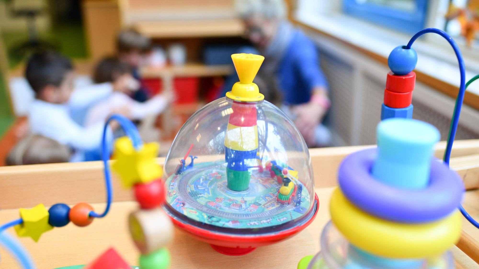 Spielzeug und Kinder im Hintergrund.