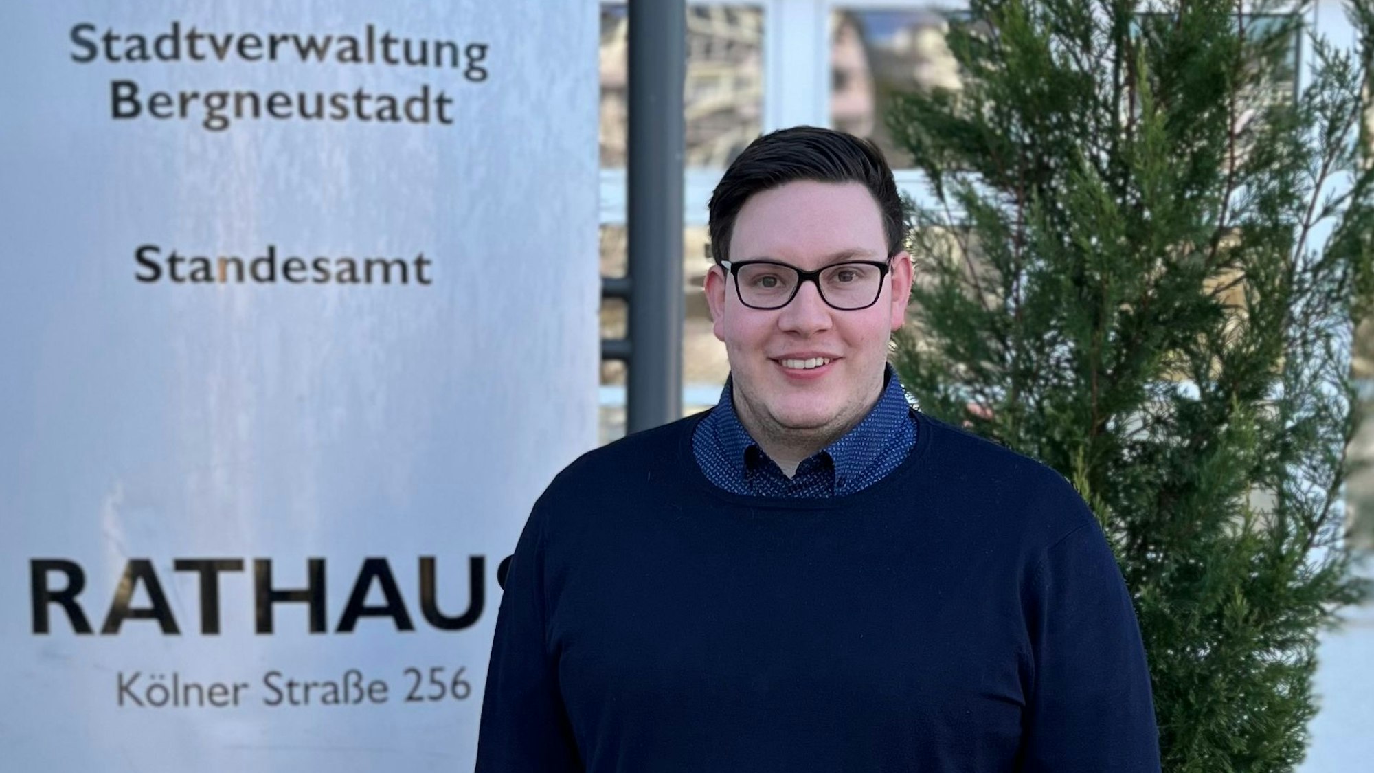 Ein junger Mann steht vor dem Rathaus in Bergneustadt.