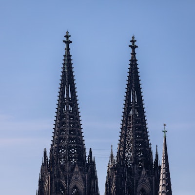 Die beiden Türme des Kölner Dom (Hohe Domkirche St. Petrus) sind vor einem blauen Himmel zu sehen.