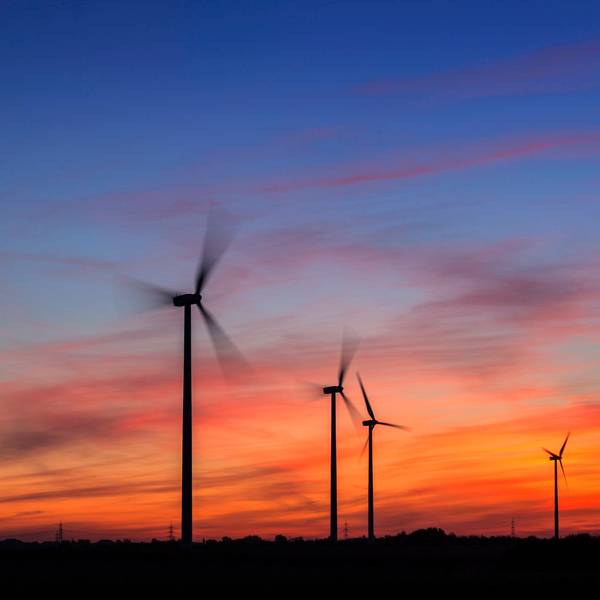 Windkrafträder am Morgen in der Nähe von Düsseldorf. Hinter ihnen geht die Sonne auf.