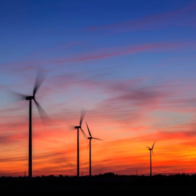 Windkrafträder am Morgen in der Nähe von Düsseldorf. Hinter ihnen geht die Sonne auf.