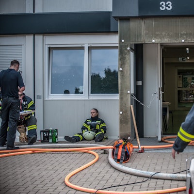 Ein Feuerwehrmann von hinten vor der Container-Wohnanlage in der Heinrich-Claes-Straße