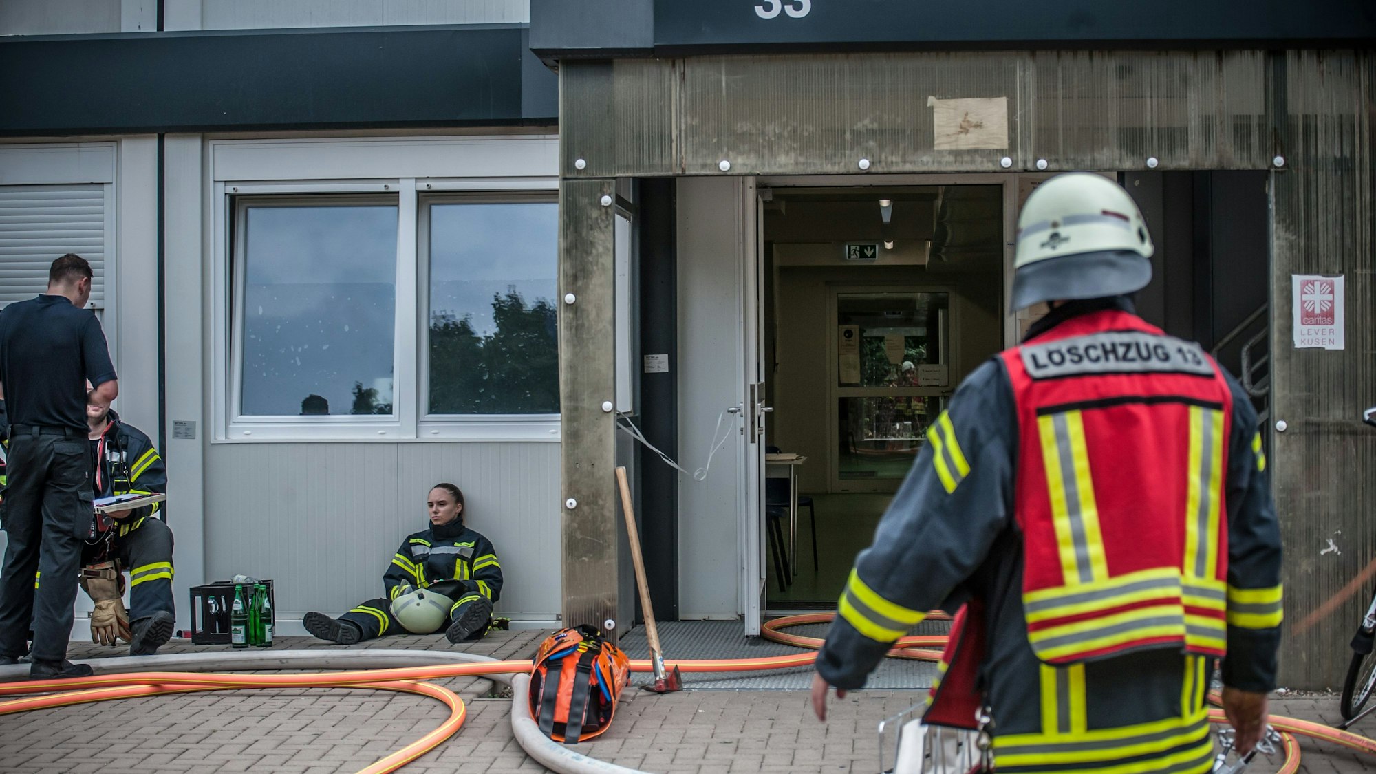 Ein Feuerwehrmann von hinten vor der Container-Wohnanlage in der Heinrich-Claes-Straße