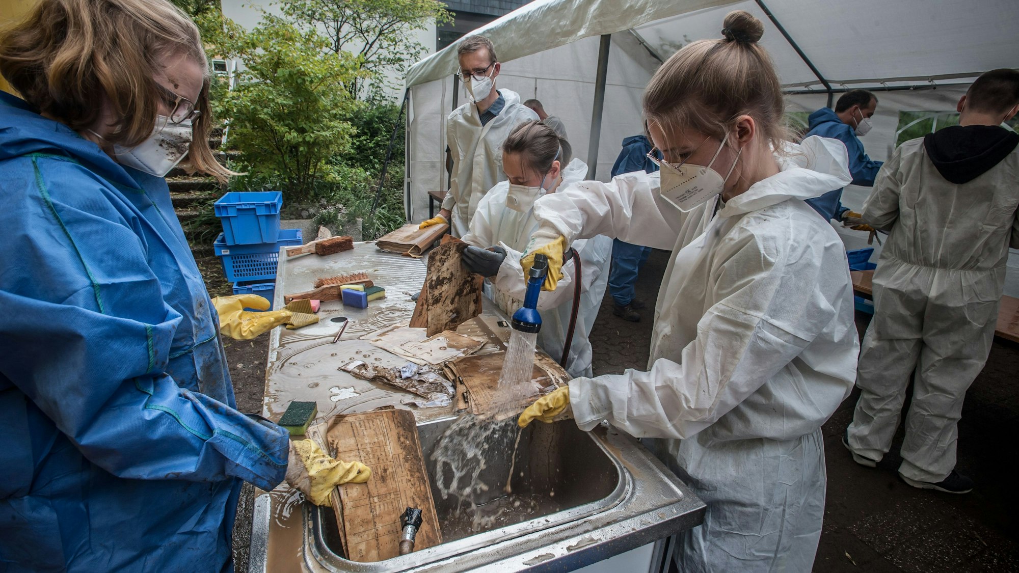 Nach dem Hochwasser: Stadtarchiv Leichlingen ist komplett überflutet gewesen. Akten und Pläne werden gewaschen, in Cellophan eingewickelt und zum Einfrieren abtransportiert.