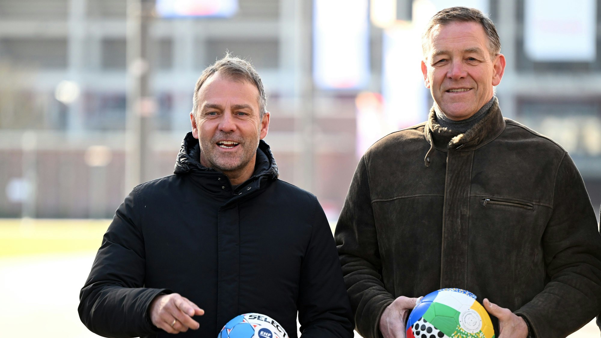 Fußball-Bundestrainer Hansi Flick (l) und Handball-Bundestrainer Alfred Gislason stehen zusammen.
