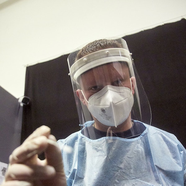 Ein Mitarbeiter eines Testzentrums in Kall mit FFP2-Maske, Sichtschutz und Schutzkleidung