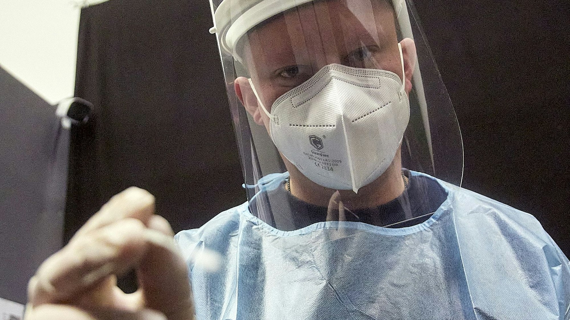 Ein Mitarbeiter eines Testzentrums in Kall mit FFP2-Maske, Sichtschutz und Schutzkleidung