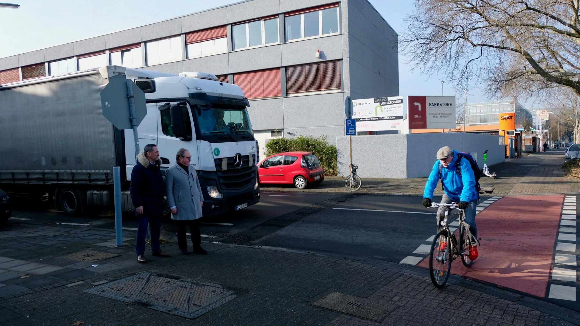 Ein Radfahrer überquert die Eupener Straße, ein Lkw steht am Stoppschild.